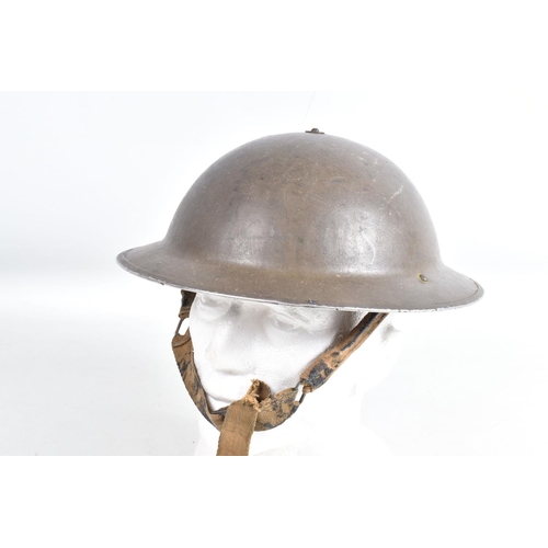 443 - A WWII 1940 DATED BRITISH STEEL HELMET AND A COLLECTION OF LATER UNIFORMS AND HATS, the helmet was p... 