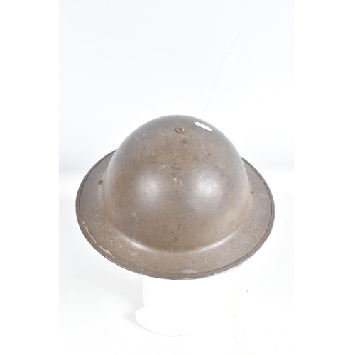 443 - A WWII 1940 DATED BRITISH STEEL HELMET AND A COLLECTION OF LATER UNIFORMS AND HATS, the helmet was p... 