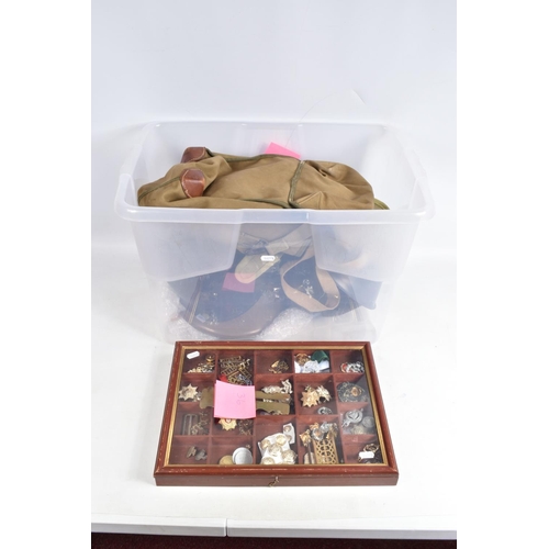 446 - A TRAY OF MILITARY CAP BADGES, five steel helmets and four military bags/ pouches, the display case ... 