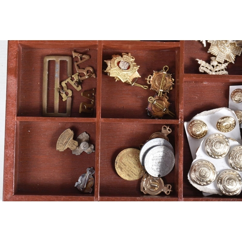 446 - A TRAY OF MILITARY CAP BADGES, five steel helmets and four military bags/ pouches, the display case ... 