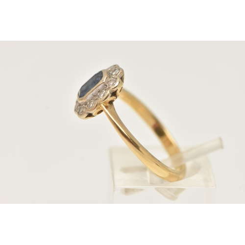 40 - AN 18CT GOLD SAPPHIRE AND DIAMOND CLUSTER RING, centering on an emerald cut blue sapphire, collet se... 