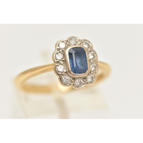 40 - AN 18CT GOLD SAPPHIRE AND DIAMOND CLUSTER RING, centering on an emerald cut blue sapphire, collet se... 