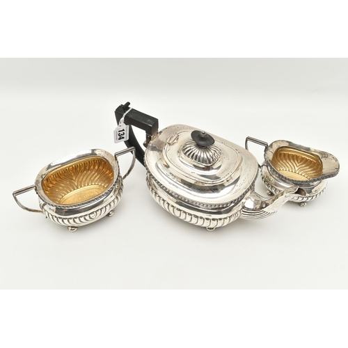 134 - A GEORGE V THREE PIECE SILVER TEA SET, comprising of a tea pot fitted with an ebonised handle and fi... 