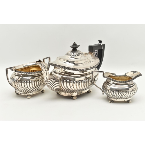 134 - A GEORGE V THREE PIECE SILVER TEA SET, comprising of a tea pot fitted with an ebonised handle and fi... 