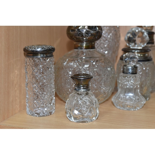 355 - EIGHT GLASS SCENT BOTTLES, with silver collars or covers, comprising a square based scent bottle, co... 