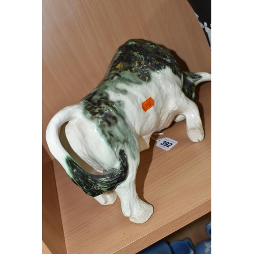 392 - A PAULA HUMPHRIES OF POLPERRO STUDIO POTTERY BULL, decorated with a black, green and white glaze, im... 