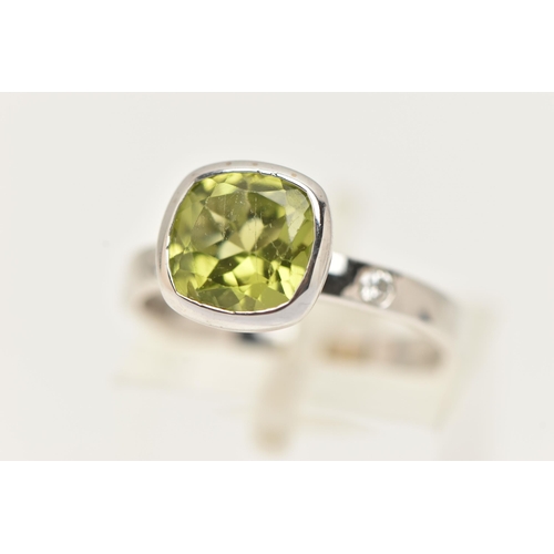 32 - A 9CT GOLD GEM SET RING, a cushion cut green stone assessed as peridot, bezel set in white gold, fla... 