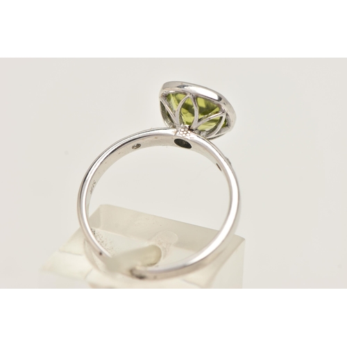 32 - A 9CT GOLD GEM SET RING, a cushion cut green stone assessed as peridot, bezel set in white gold, fla... 