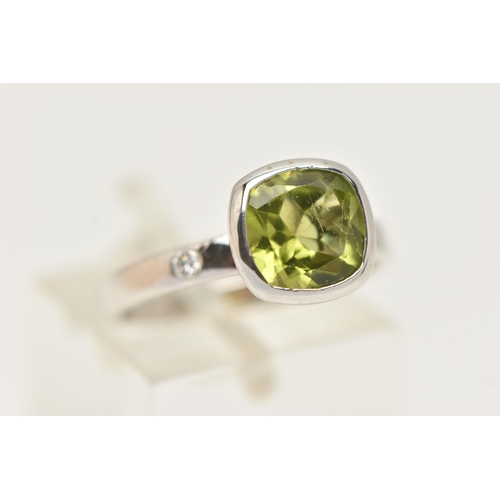 32 - A 9CT GOLD GEM SET RING, a cushion cut green stone assessed as peridot, bezel set in white gold, fla... 