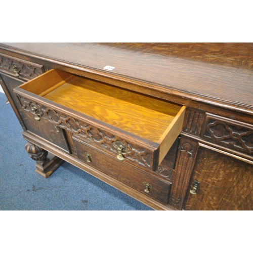 1209 - AN EARLY 20TH CENTURY OAK SIDEBOARD, with a raised back, five assorted drawers, two cupboard doors, ... 