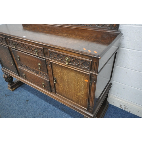 1209 - AN EARLY 20TH CENTURY OAK SIDEBOARD, with a raised back, five assorted drawers, two cupboard doors, ... 