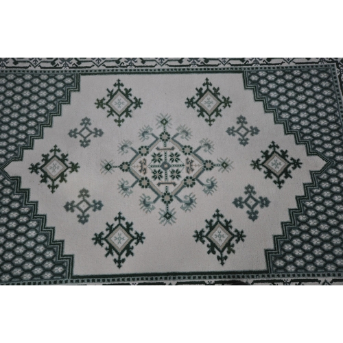 1213 - A RECTANGULAR CREAM AND GREEN WOOLEN RUG, 244cm x 172cm, along with a matching runner (condition rep... 