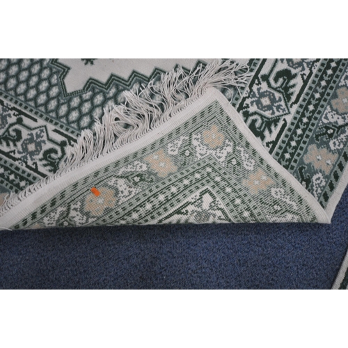 1213 - A RECTANGULAR CREAM AND GREEN WOOLEN RUG, 244cm x 172cm, along with a matching runner (condition rep... 