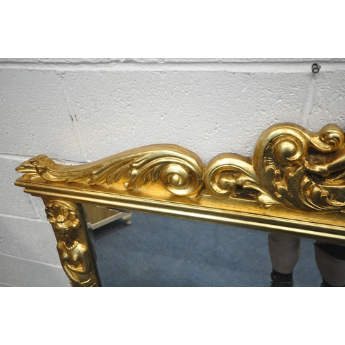 1237 - A LARGE FLAMBOYANT REPRODUCTION GILT WOOD BEVELED EDGE OVERMANTEL MIRROR, the crest depicting two se... 