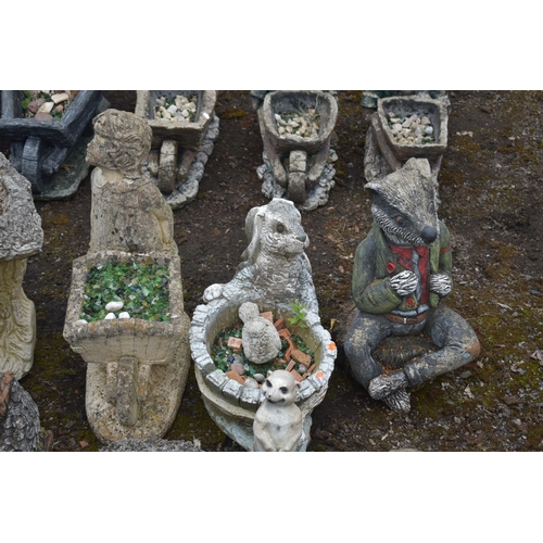 1008 - A COLLECTION OF GARDEN ORNAMENTS, to include a composite wheelbarrow planter, an animal wheelbarrow ... 