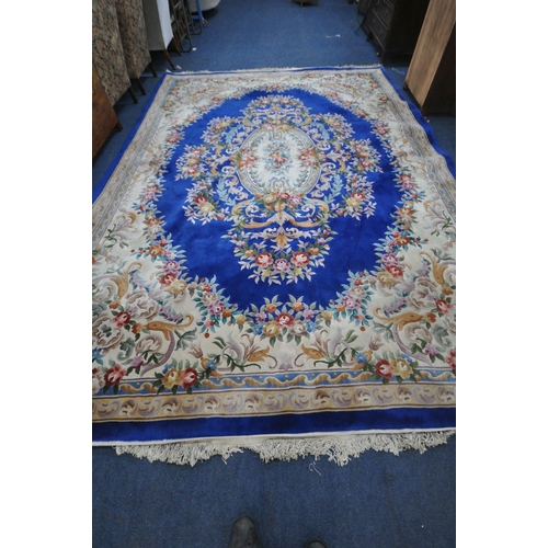 1276 - A VERY LARGE BLUE GROUND RECTANGULAR CHINESE RUG, with floral central medallion and border, 440cm x ... 