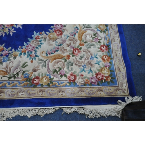 1276 - A VERY LARGE BLUE GROUND RECTANGULAR CHINESE RUG, with floral central medallion and border, 440cm x ... 