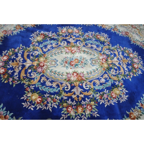 1276 - A VERY LARGE BLUE GROUND RECTANGULAR CHINESE RUG, with floral central medallion and border, 440cm x ... 