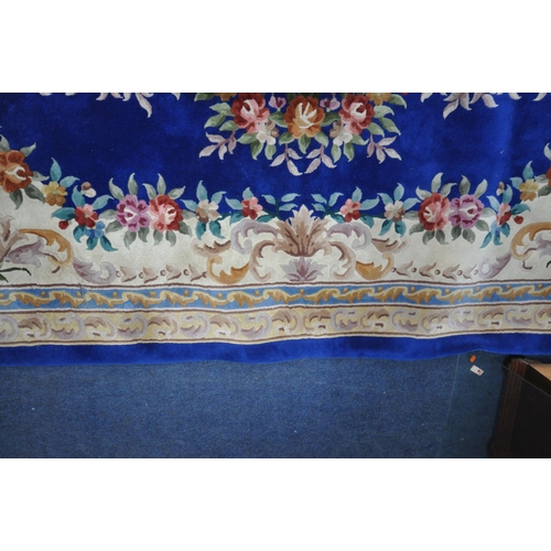 1276 - A VERY LARGE BLUE GROUND RECTANGULAR CHINESE RUG, with floral central medallion and border, 440cm x ... 