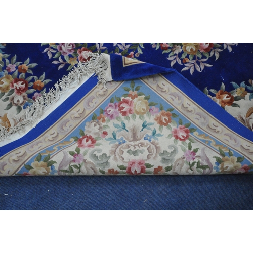 1276 - A VERY LARGE BLUE GROUND RECTANGULAR CHINESE RUG, with floral central medallion and border, 440cm x ... 