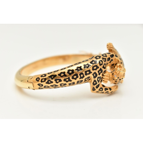 18 - A 'CARRERA Y CARRERA' BRACELET, a Spanish, yellow metal hinged bangle, depicting two leopards, round... 