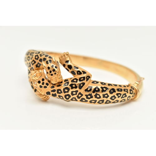 18 - A 'CARRERA Y CARRERA' BRACELET, a Spanish, yellow metal hinged bangle, depicting two leopards, round... 