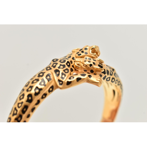 18 - A 'CARRERA Y CARRERA' BRACELET, a Spanish, yellow metal hinged bangle, depicting two leopards, round... 