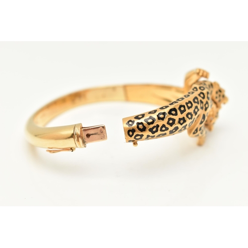 18 - A 'CARRERA Y CARRERA' BRACELET, a Spanish, yellow metal hinged bangle, depicting two leopards, round... 