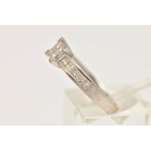 25 - AN 18CT GOLD DIAMOND RING, designed as four princess cut diamonds in an invisible setting, flanked w... 