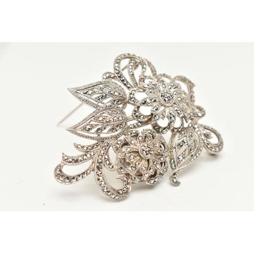 38 - A 'BUCHERER' BROOCH WATCH, a white metal floral brooch set with marcasite, hinged flower lifting to ... 