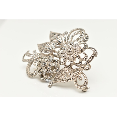 38 - A 'BUCHERER' BROOCH WATCH, a white metal floral brooch set with marcasite, hinged flower lifting to ... 