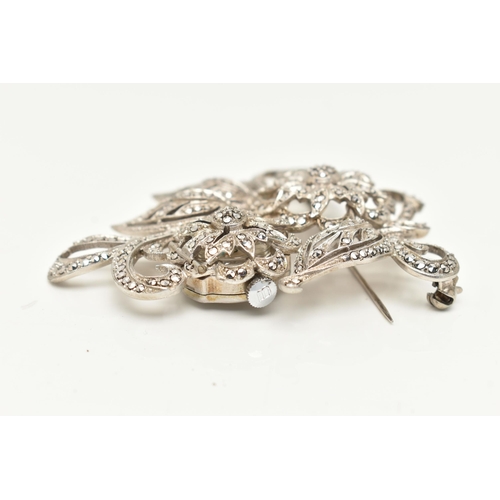 38 - A 'BUCHERER' BROOCH WATCH, a white metal floral brooch set with marcasite, hinged flower lifting to ... 