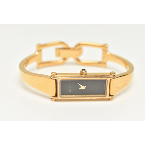 52 - A LADIES 'GUCCI' WRISTWATCH, quartz movement, rectangular black dial, signed 'Gucci', gold plated ca... 