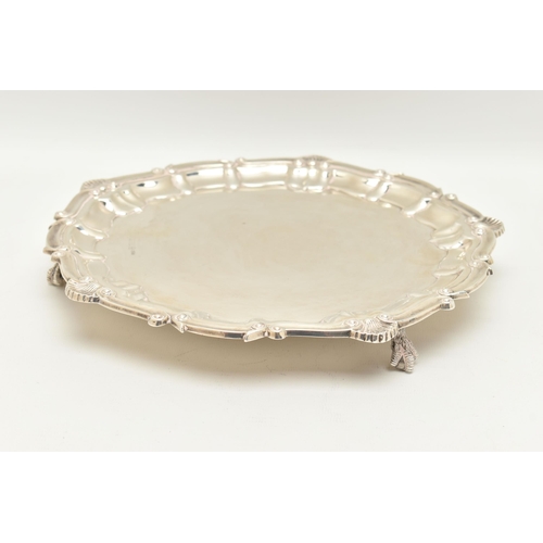 74 - AN ELIZABETH II SILVER SALVER, the shell and scroll cast rim and pie crust edge surrounding a plain ... 