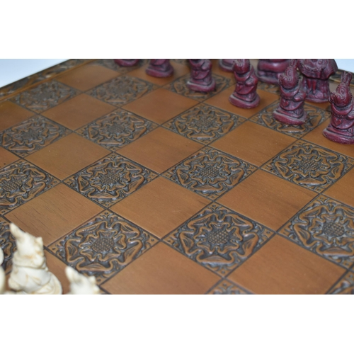 515 - AN ALICE IN WONDERLAND CHESS BOARD AND SET OF THIRTY TWO CHESS PIECES IN RED AND WHITE, comprising  ... 