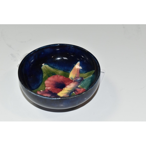 325 - A MOORCROFT POTTERY 'ORCHID' SMALL FOOTED BOWL, tube lined with a pink, yellow and purple Orchid on ... 