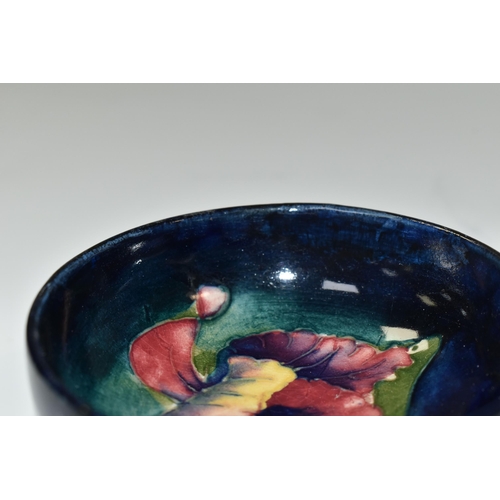 325 - A MOORCROFT POTTERY 'ORCHID' SMALL FOOTED BOWL, tube lined with a pink, yellow and purple Orchid on ... 