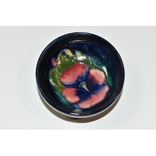 351 - A MOORCROFT POTTERY 'PANSY' SMALL FOOTED BOWL, tube lined with a pink and purple Pansy on a dark blu... 