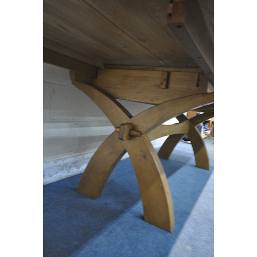 1218 - JB GLOBAL, A MODERN SOLID OAK EXTENDING TABLE, with two additional fold out leaves, raised on cross ... 