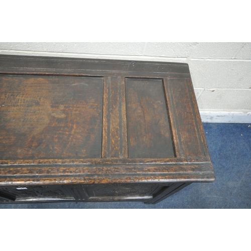 1243 - A GEORGIAN OAK COFFER, the hinged lid enclosing a candle box, the front with three carved panels, wi... 