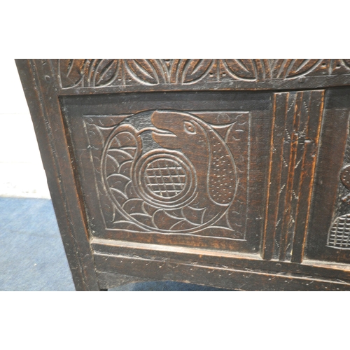 1243 - A GEORGIAN OAK COFFER, the hinged lid enclosing a candle box, the front with three carved panels, wi... 