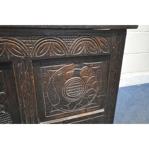 1243 - A GEORGIAN OAK COFFER, the hinged lid enclosing a candle box, the front with three carved panels, wi... 