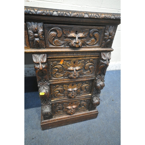 1250 - A 20TH CENTURY OAK CARVED GREEN MAN TWIN PEDESTAL DESK, with leather writing surface, fitted with an... 