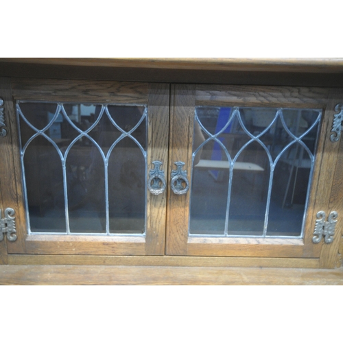 1251 - AN OLD CHARM OAK COURT CUPBOARD, fitted with double lead glazed doors, turned supports, three drawer... 