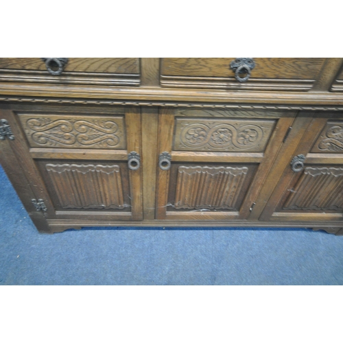 1251 - AN OLD CHARM OAK COURT CUPBOARD, fitted with double lead glazed doors, turned supports, three drawer... 