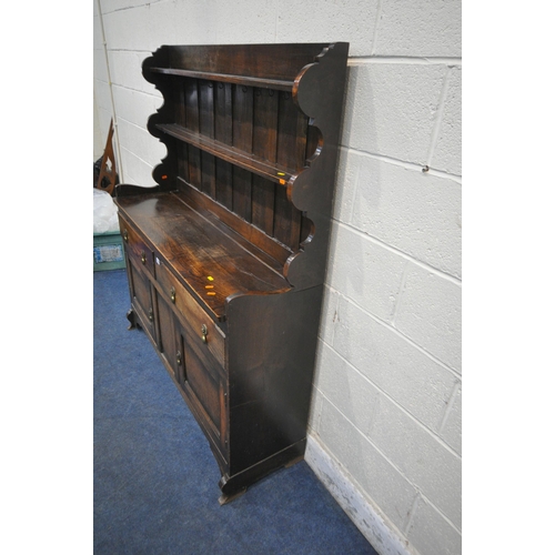 1256 - AN EARLY 20TH CENTURY OAK DRESSER, the two tier plate rack, with wavy sides, atop a base with two dr... 