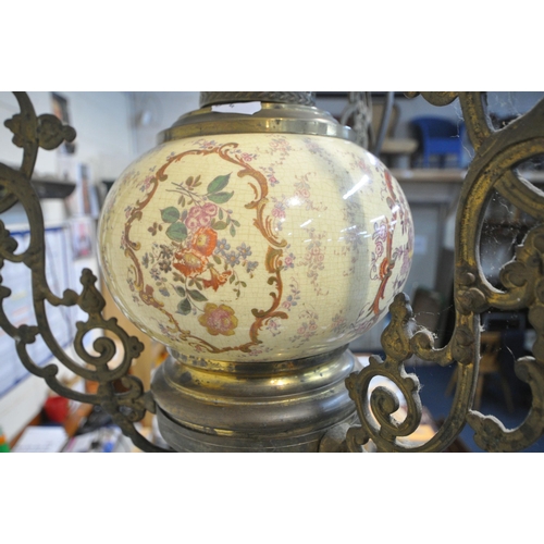 1293 - A 19TH CENTURY HANGING BRASS OIL LAMP, converted to electric, the flamboyant frame cradling a white ... 