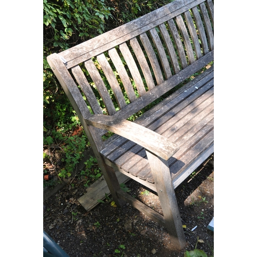 1020 - A MODERN HARDWOOD GARDEN BENCH width 139cm with slatted back and seat along with a modern cast iron ... 