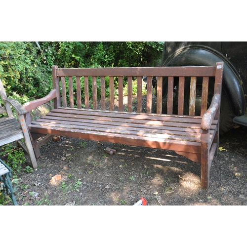 1021 - A MODERN HARDWOOD GARDEN BENCH with carved arm rests, slatted back and seat width 181cm