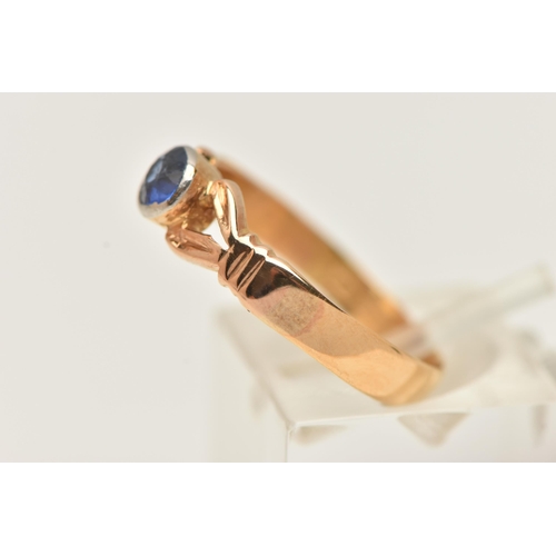 22 - A 22CT GEM SET RING, a circular cut blue stone, bezel set in yellow gold, leading on to bifurcated s... 